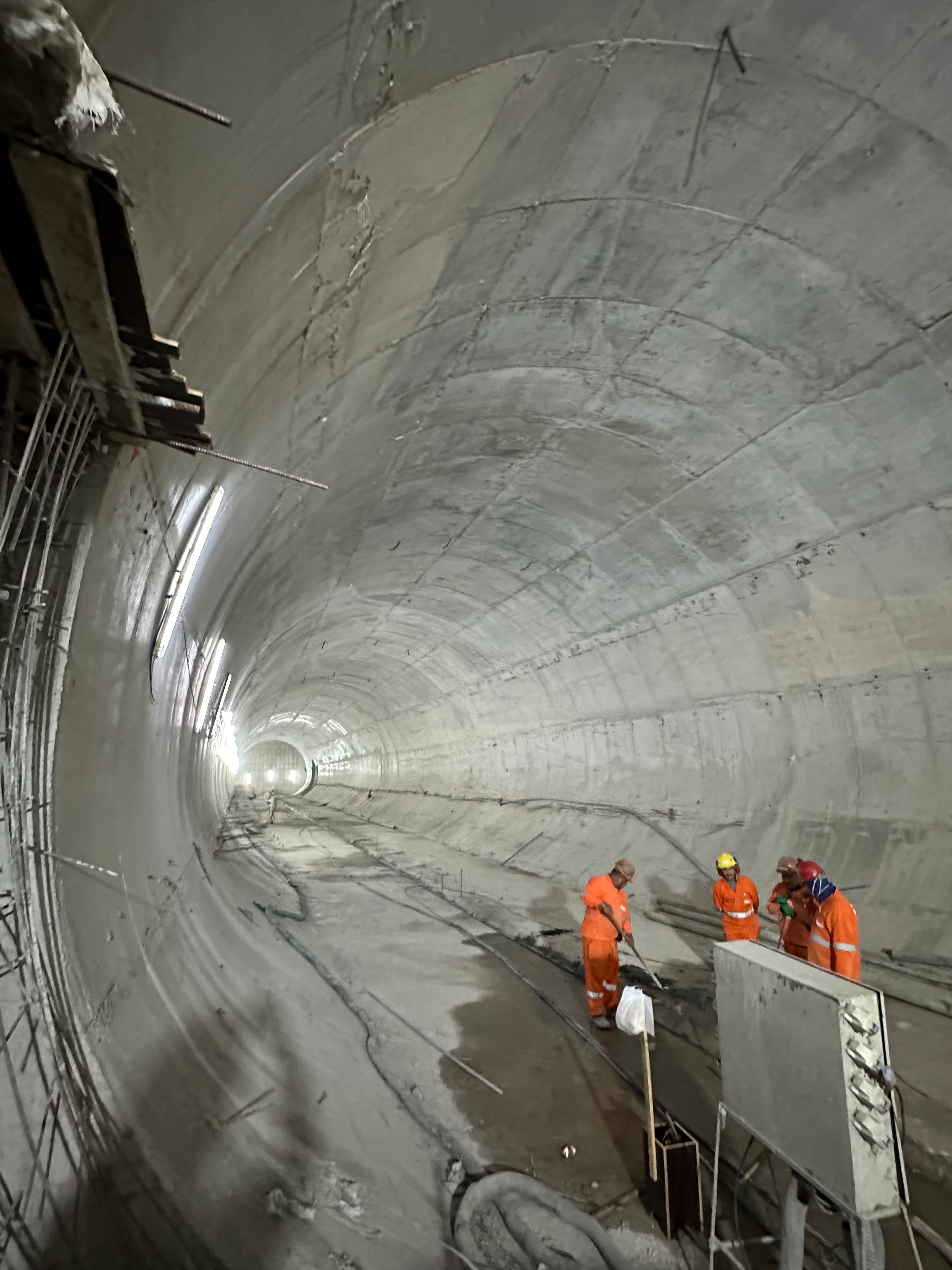 Trabalhadores dentro de um túnel de concreto em construção